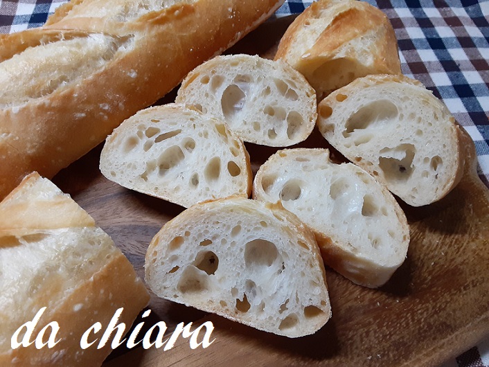 木のまな板の上でスライスされたバゲットが並んでいる。大小の気泡が見える