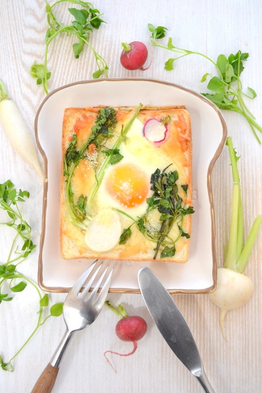トーストの上に目玉焼きと七草を配置して焼いているのを上から見た画像